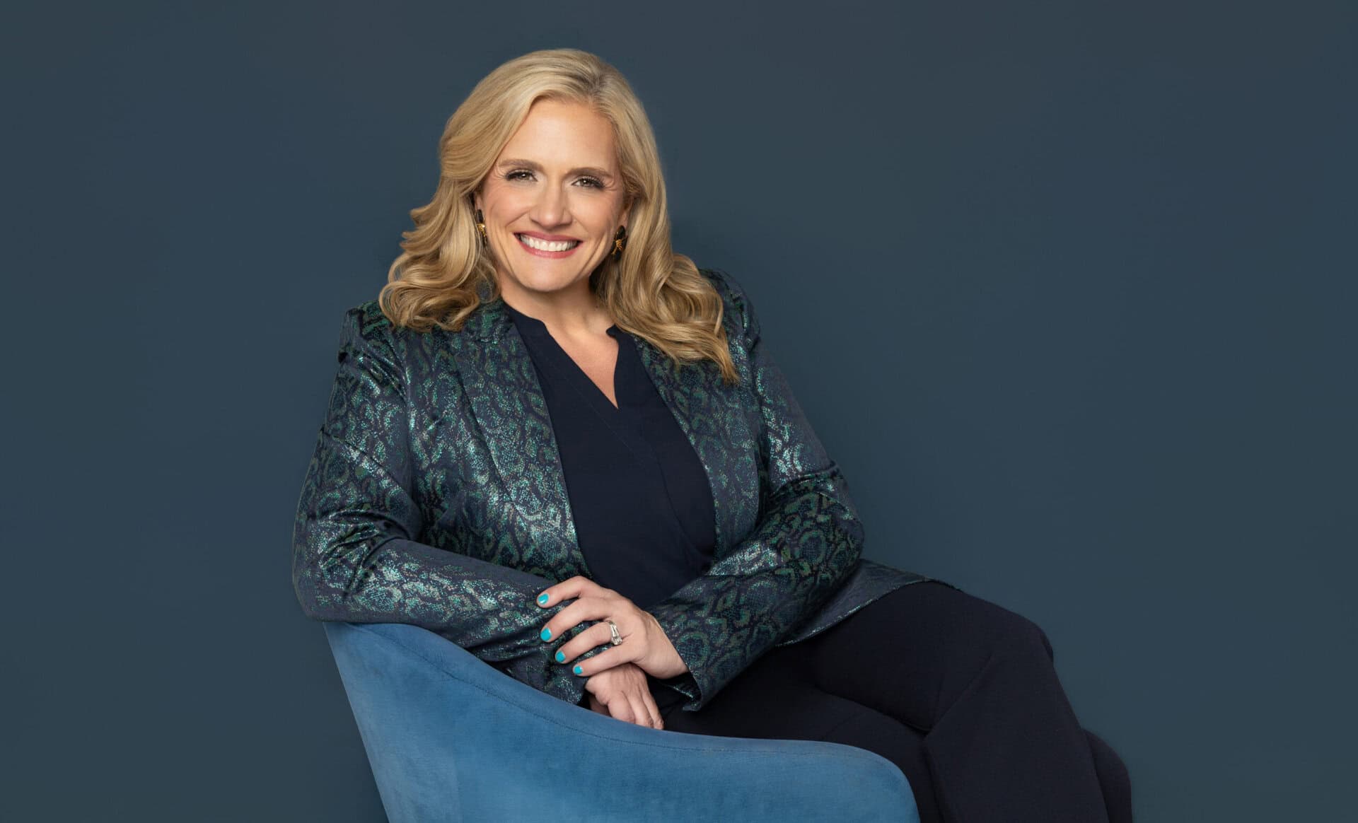 Estelle Winsett, former litigator and law firm image consultant, wearing a teal metallic blazer